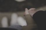 A close-up of intertwined fingers with a blurred romantic background.