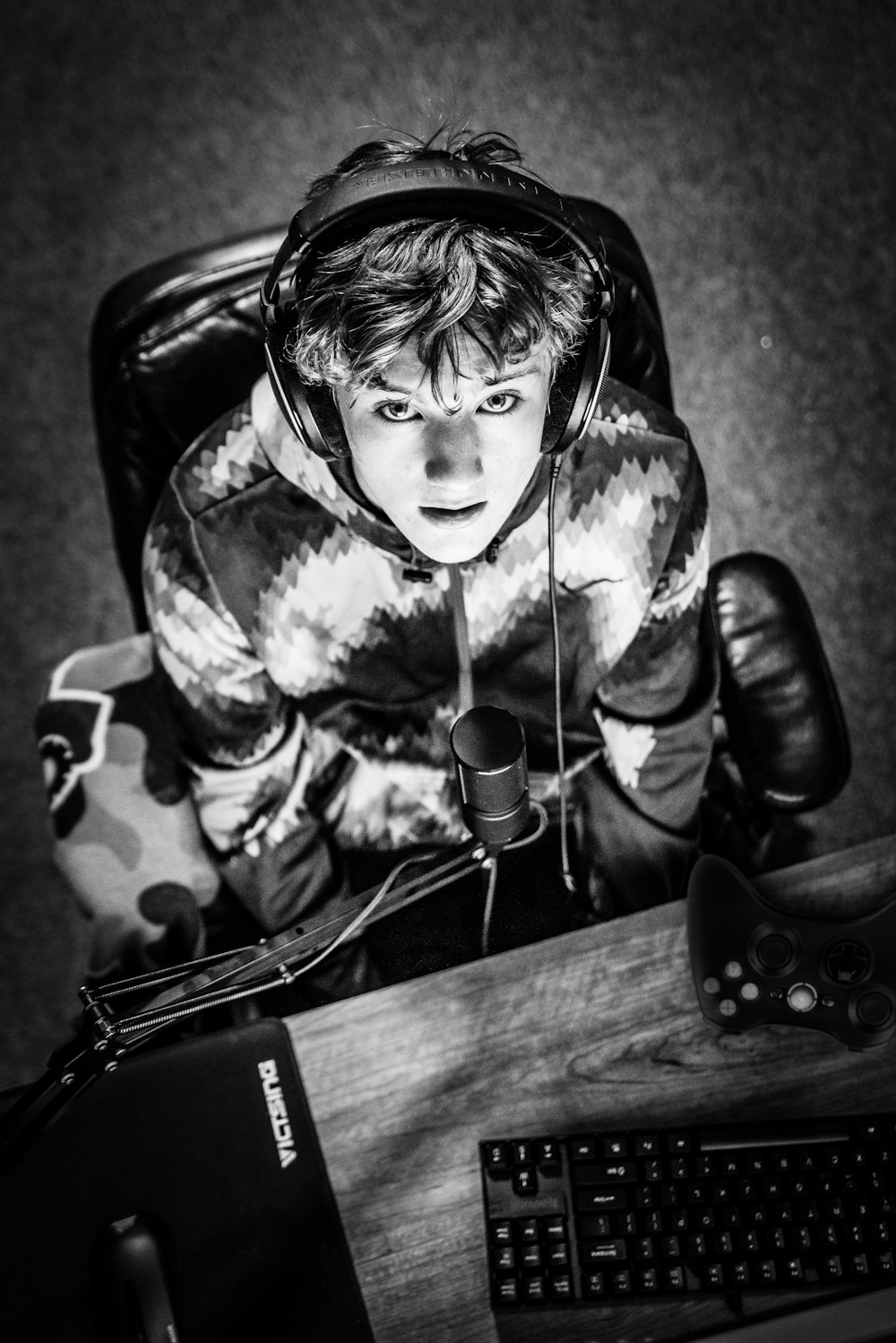 grayscale photography of man sitting on office rolling armchair