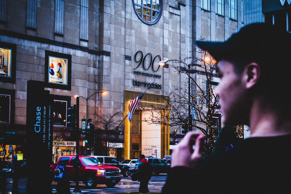 shallow focus photo of man standing in front of building