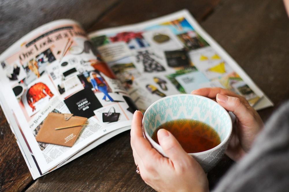 shallow focus photo of person holding ceramic mug