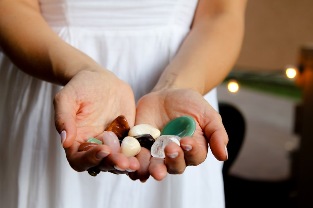 woman holding assorted-color pebbles