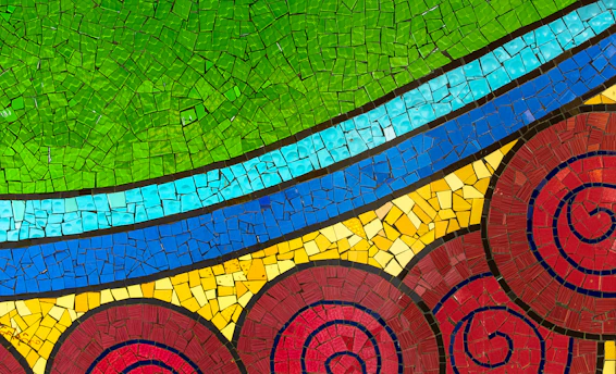 A close-up of colorful mosaic tiles forming a radiant, intricate pattern symbolizing healing and strength.