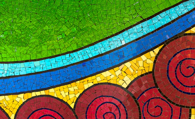 A close-up of colorful mosaic tiles forming a radiant pattern symbolizing healing and strength.