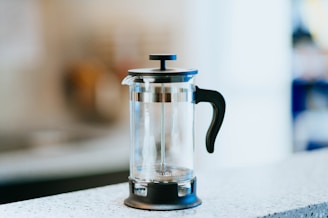 A rustic brown French press steaming on a cozy kitchen counter.