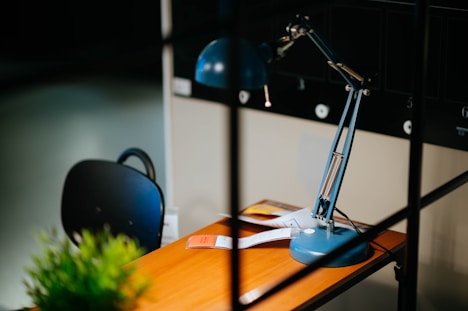 blue desk lamp on brown wooden desk