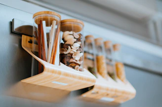 A handcrafted wooden spice rack filled with colorful jars of spices on a kitchen counter.