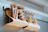 Close-up of a rustic hanging wall basket rack holding jars of spices in a bright kitchen.