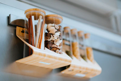 A handcrafted wooden spice rack filled with colorful jars of spices on a kitchen counter.