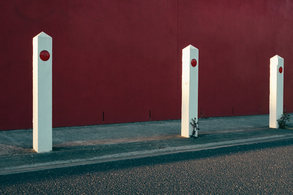 three white posts on road side