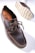 A dark brown leather shoe with detailed stitching and a thick, textured sole is prominently displayed. The shoe features a lace-up design and visible branding on the inner sole. The sole's pattern is visible, showcasing its rugged, slip-resistant design.