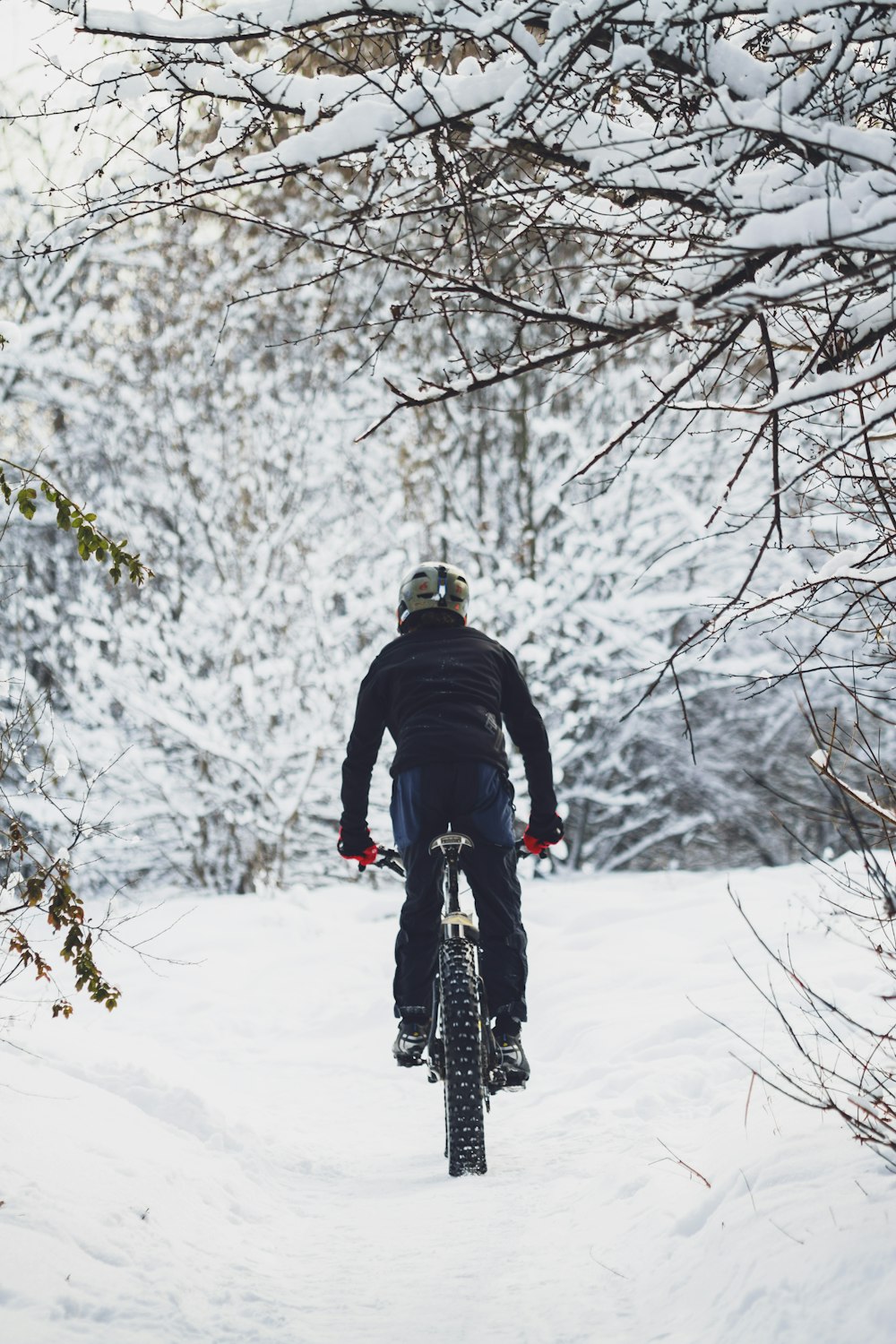 man riding bicycle on snow