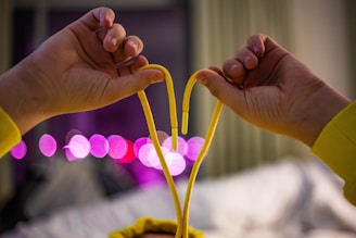 Hands gently holding a red string tied in a knot symbolizing love binding.