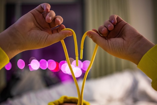 Hands gently holding a red string tied in a knot symbolizing love binding.