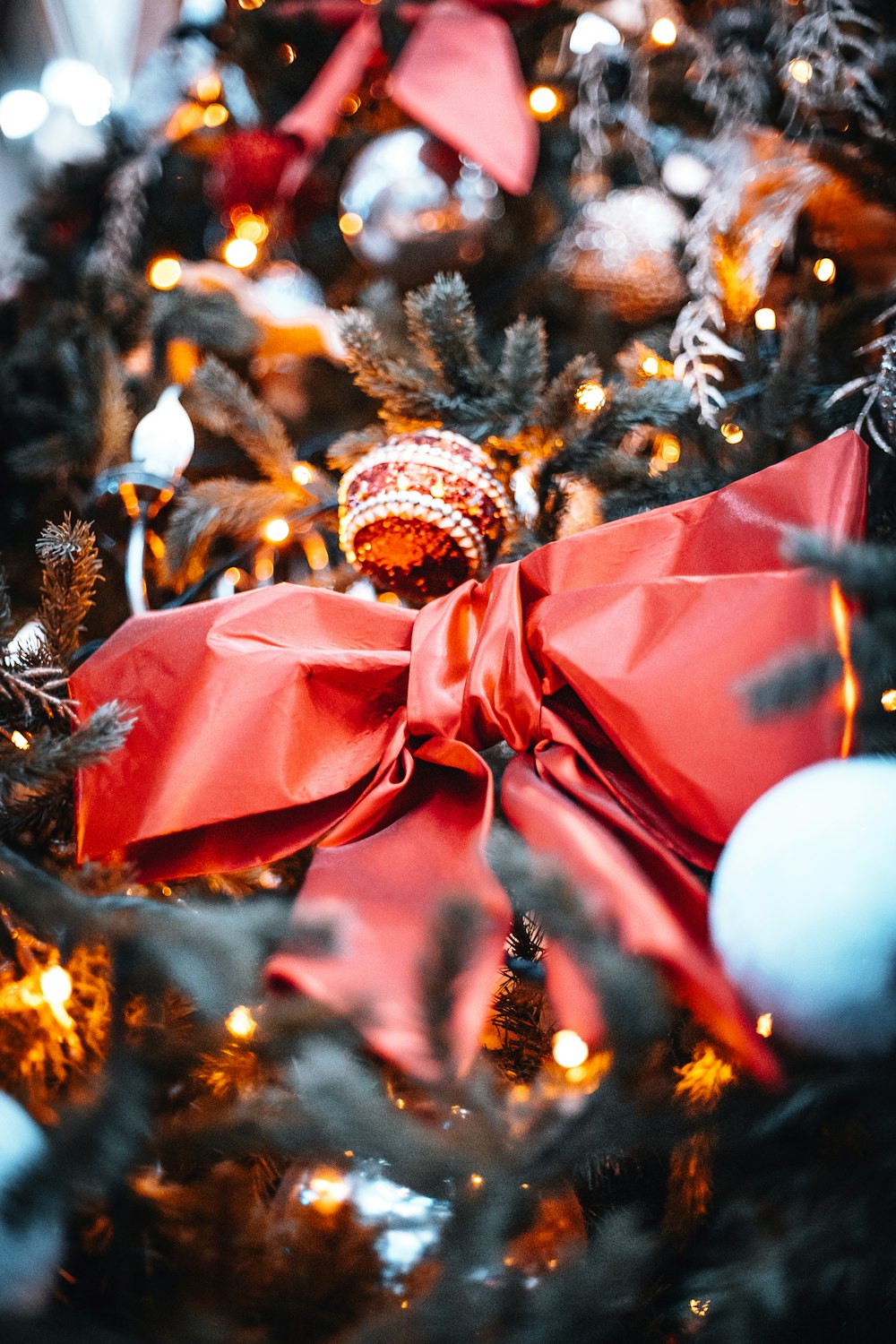 selective focus photography of red bow and Christmas baubles