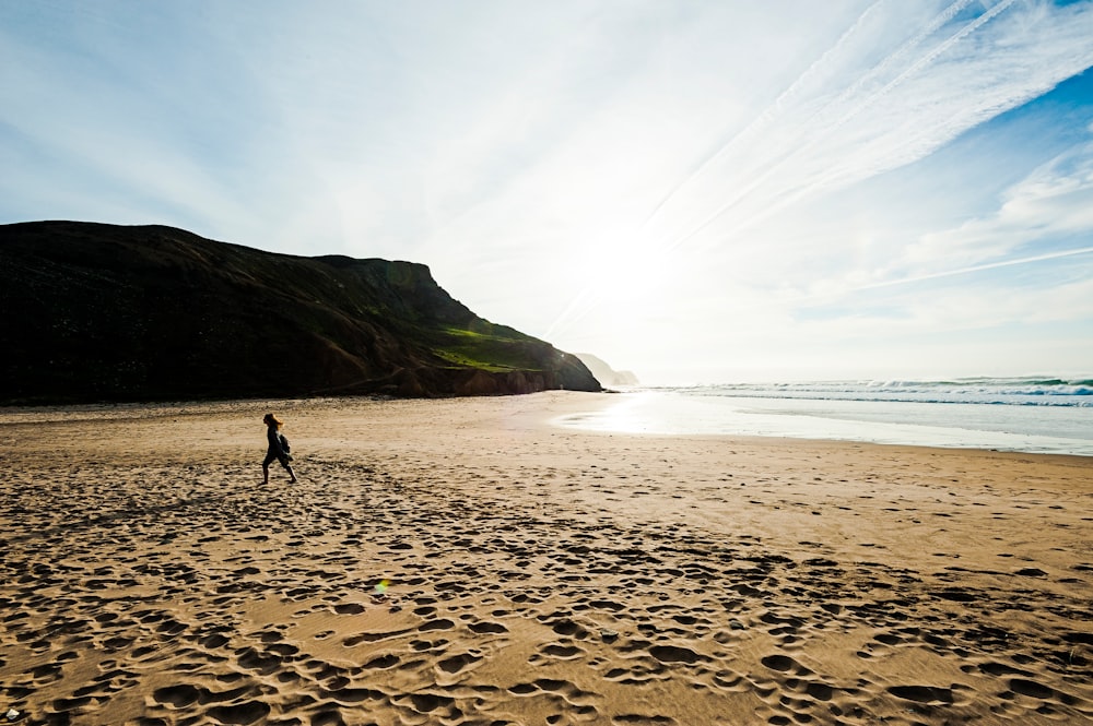 woman walking on brown beach sand