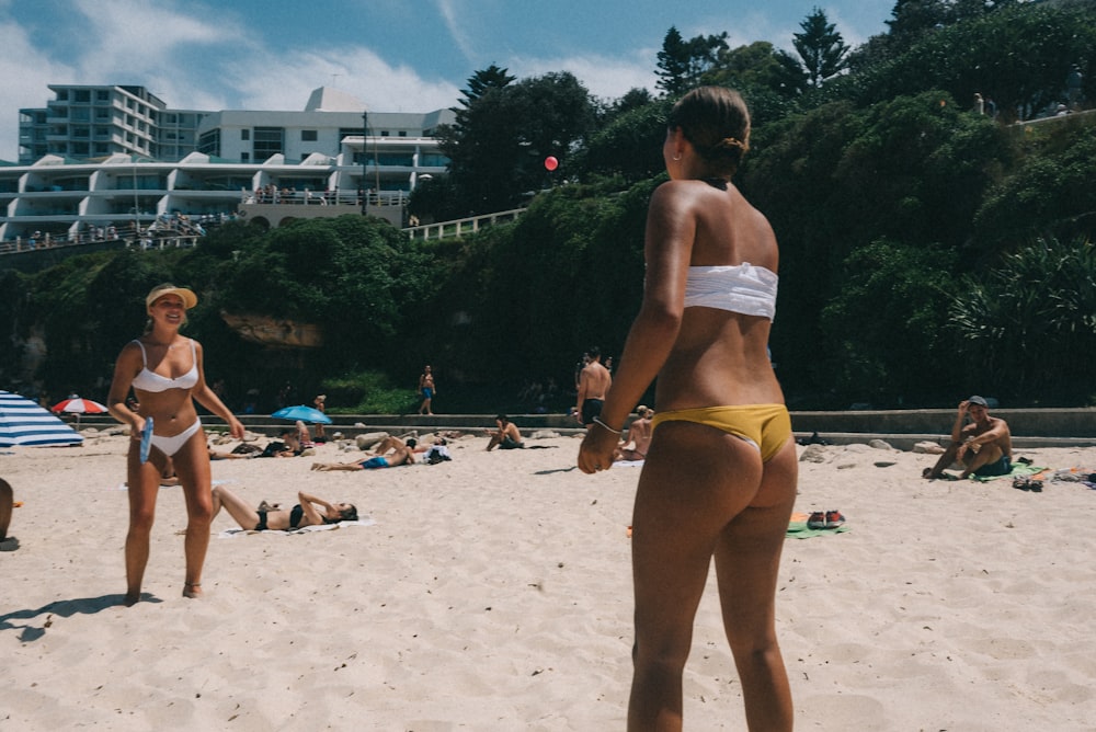 two women wearing bikinis on brown sands