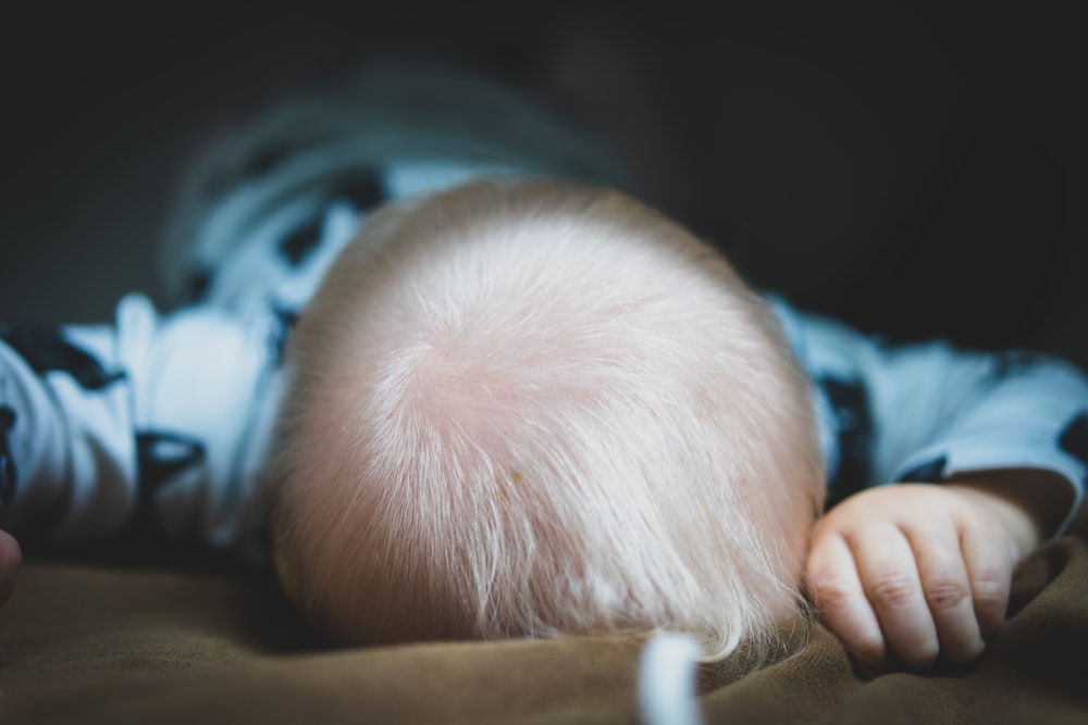 toddler lying on bed