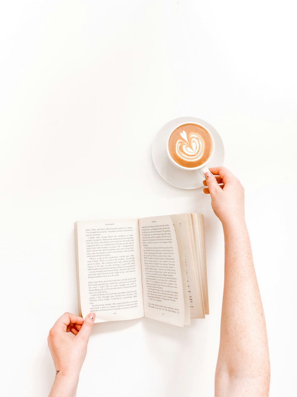 Persona piana della fotografia di disposizione che tiene la tazza con il latte ed il libro