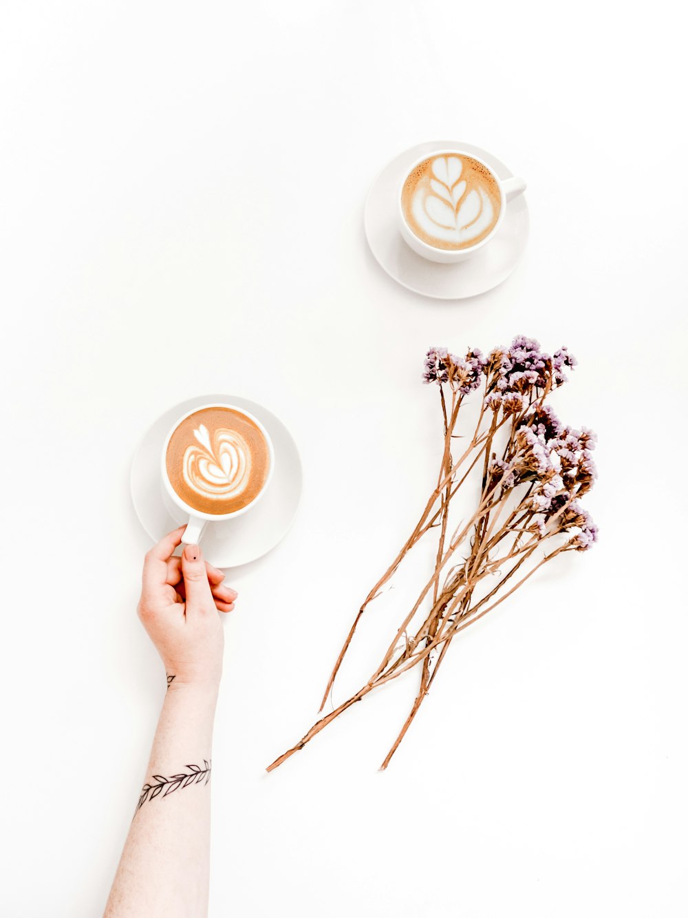 two cups near pink flowers