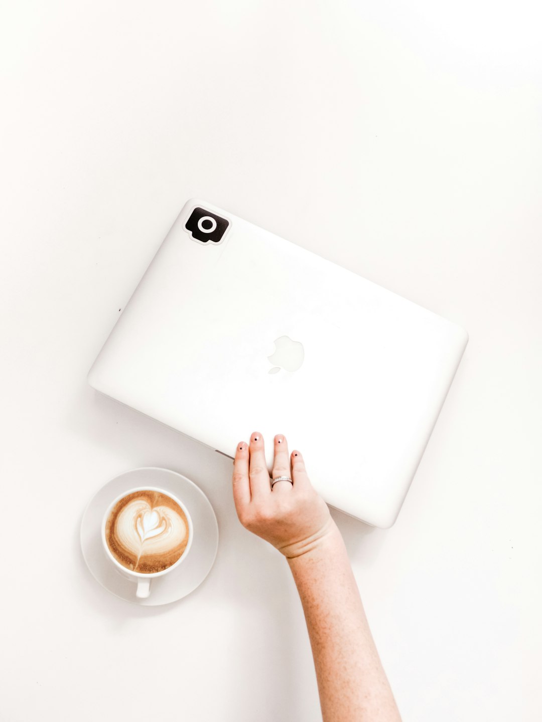 person holding Apple product near mug