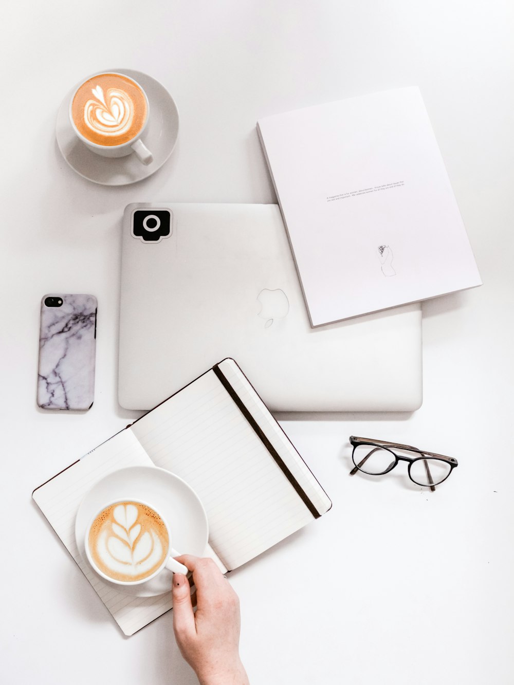 flat lay photography of coffee latte on top of open planner and MacBook