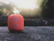 Modern wireless speaker glowing softly on a cozy living room shelf.