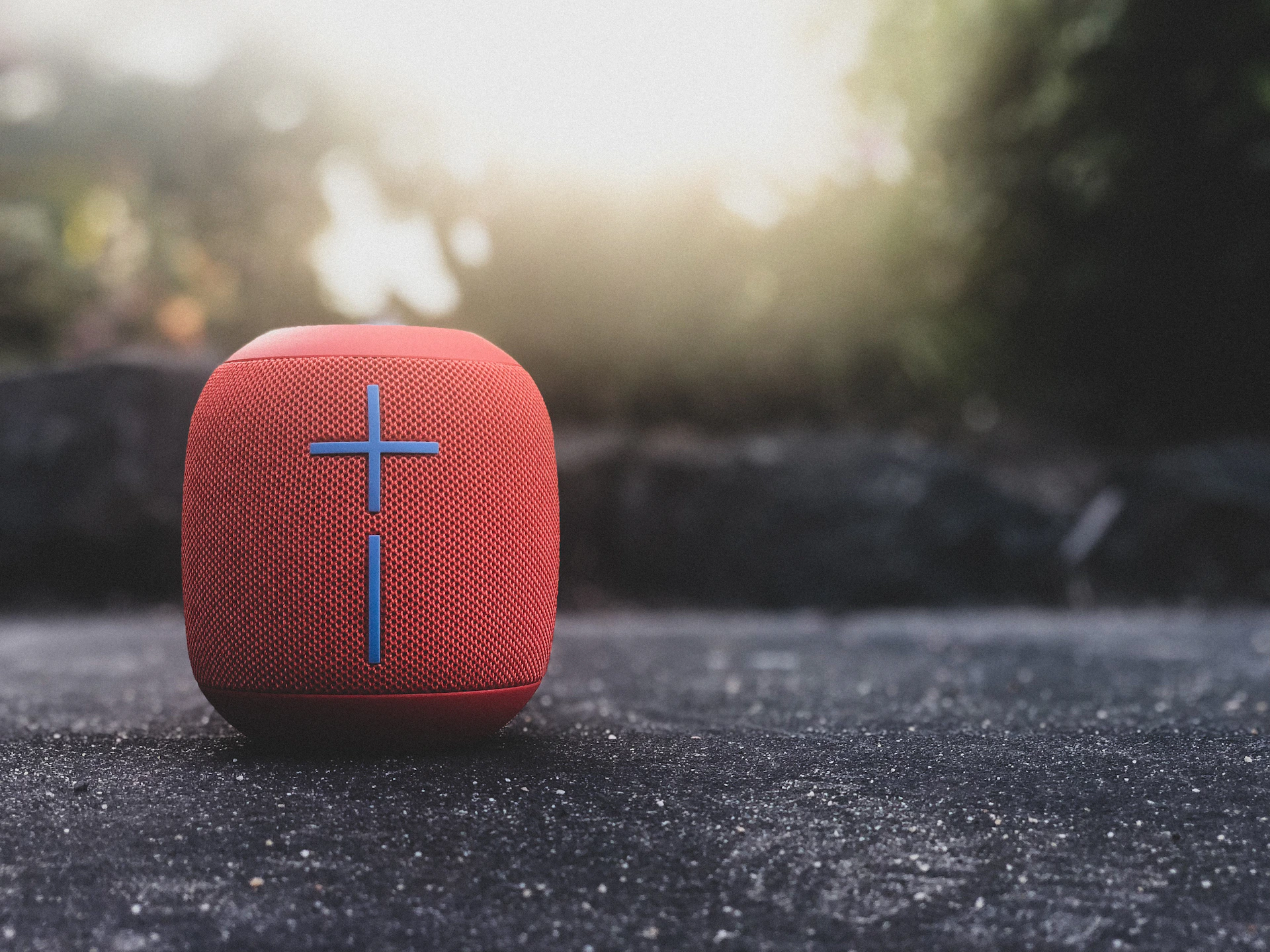 A Village Sounds speaker glowing softly in a cozy living room setting, with warm ambient lighting.