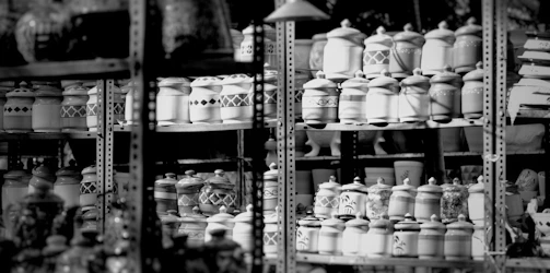 Antique pottery jars arranged artfully on a minimalist shelf.