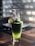 A vibrant glass of green smoothie garnished with fresh mint leaves on a wooden table.