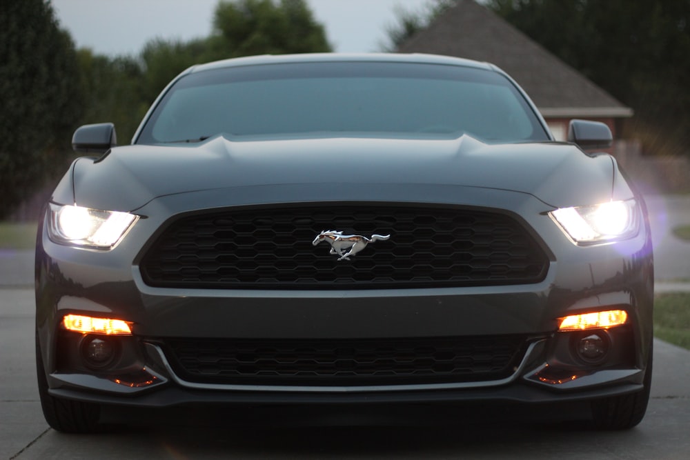 black Ford Mustang on gray pavement