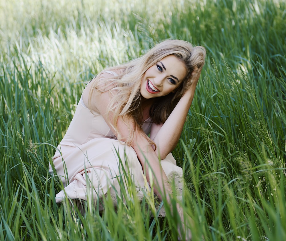 woman touching her hair and surrounded by grass