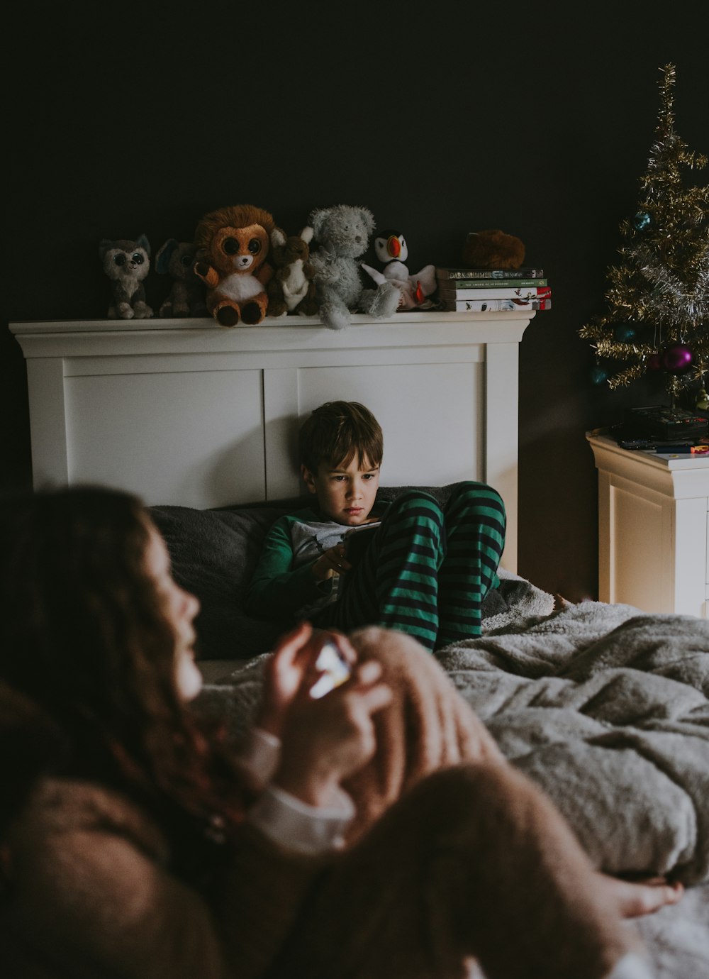 boy sitting on bed inside room