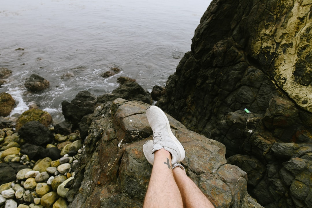person resting legs on rock