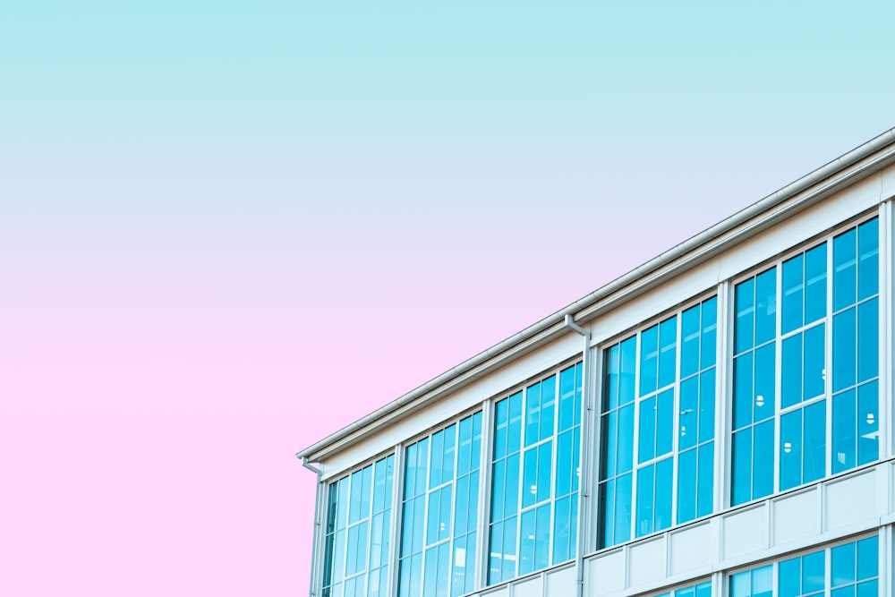 Edificio di vetro blu sotto il cielo viola durante il giorno