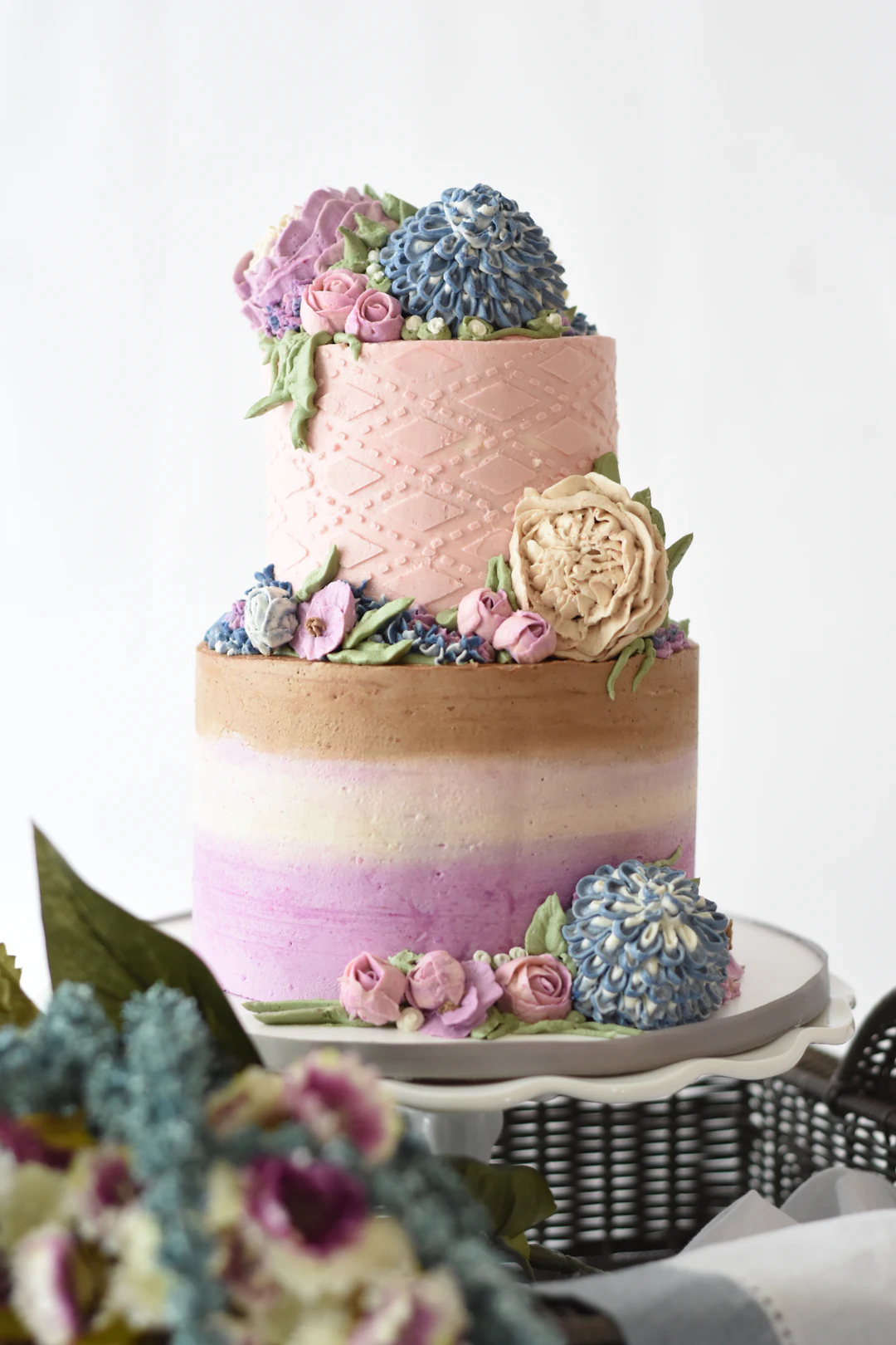 A two tier custom Sweet 16 cake on a cake stand, decorated for a milestone teen birthday party