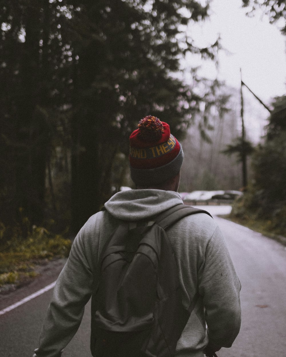 man standing on gray road