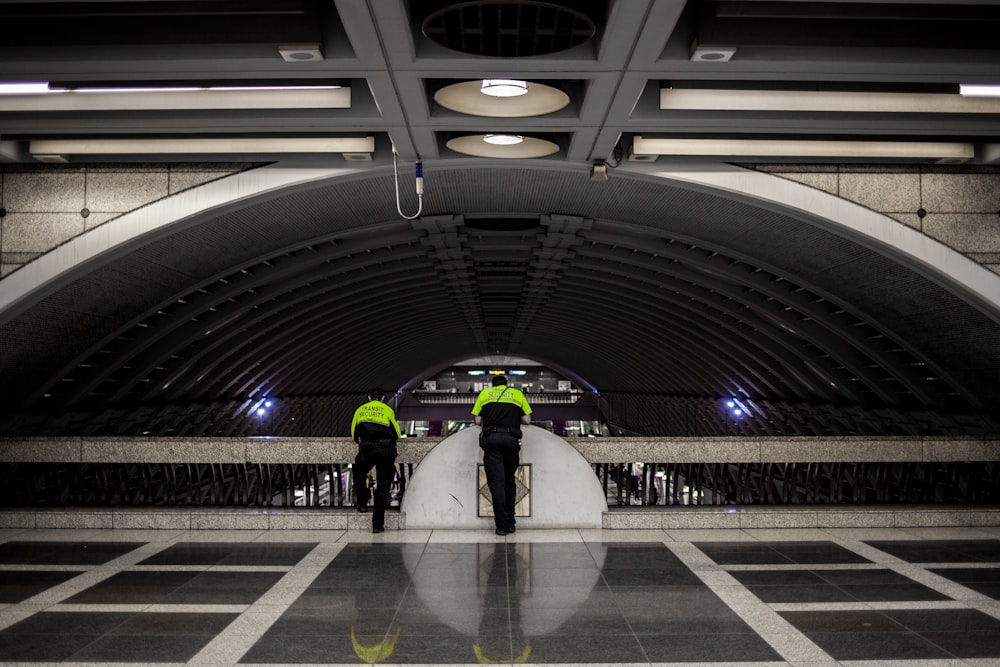 photographie de paysage de deux hommes appuyés sur une barricade