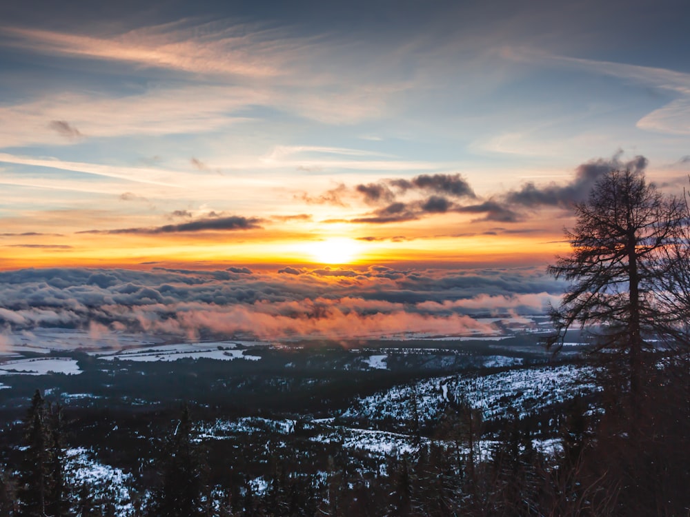 clouds, trees, and mountains during golden hour