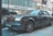 A sleek, luxury car is parked on a city street in front of a store called French Connection, with large windows reflecting the urban environment. The car is shiny and appears to be well-maintained, adding an air of sophistication and wealth to the scene.