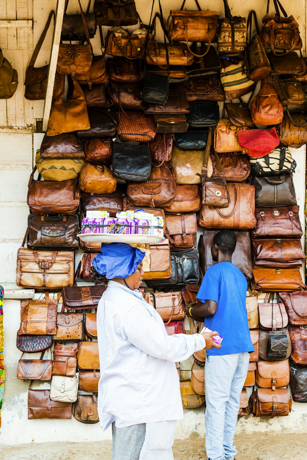 man standing beside brown leather bag lot