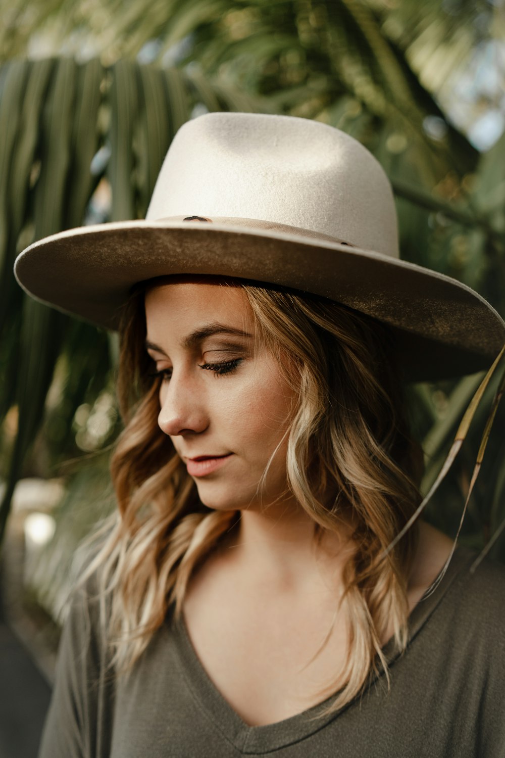 woman wearing brown crew neck shirt with round hat