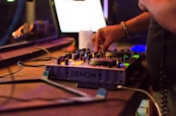 Close-up of a hand adjusting a synth knob while working on a new beat.