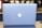 A sleek, silver laptop displaying a prominent glowing apple logo on its lid, set against a blurred background with soft lighting.
