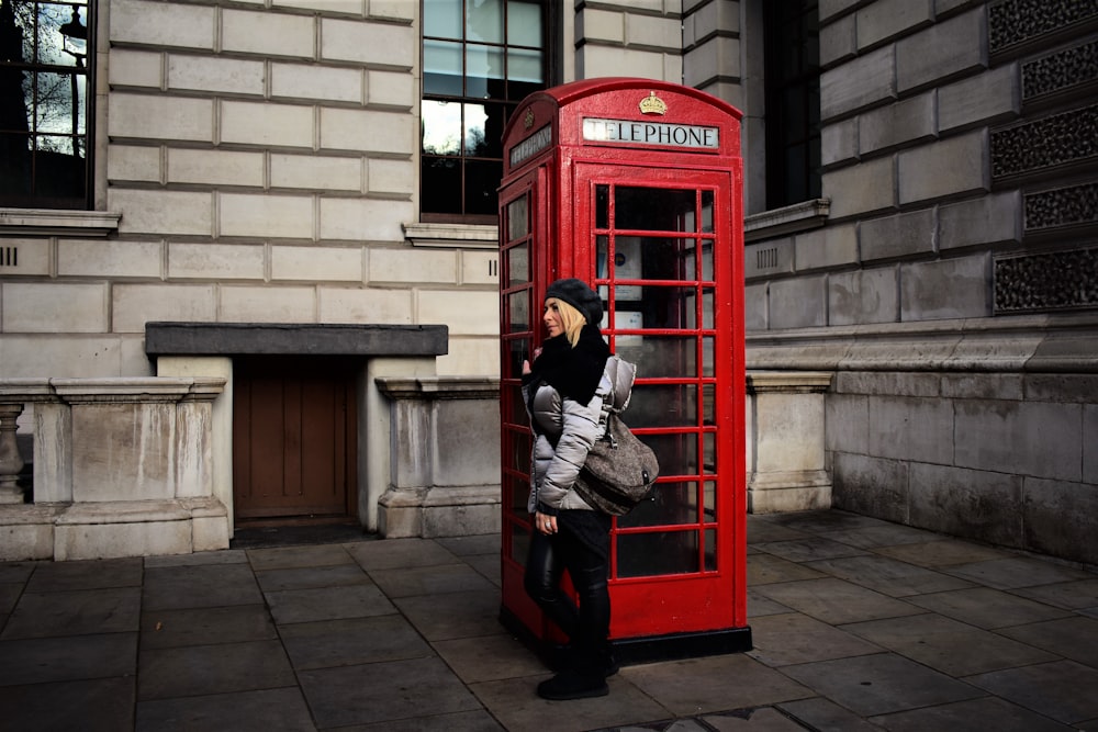 woman standing next to telephone booth