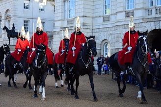 man wearing red coat riding horses during daytime