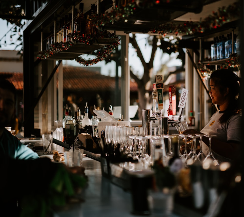 selective focus photography of woman holding glass near beer dispenser