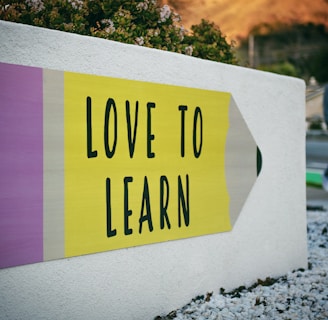 love to learn pencil signage on wall near walking man