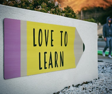 love to learn pencil signage on wall near walking man