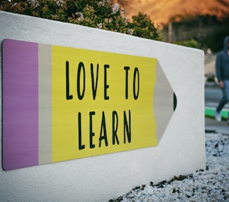 love to learn pencil signage on wall near walking man