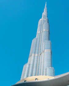 A towering modern commercial building under clear blue skies, showcasing sleek glass and steel architecture.